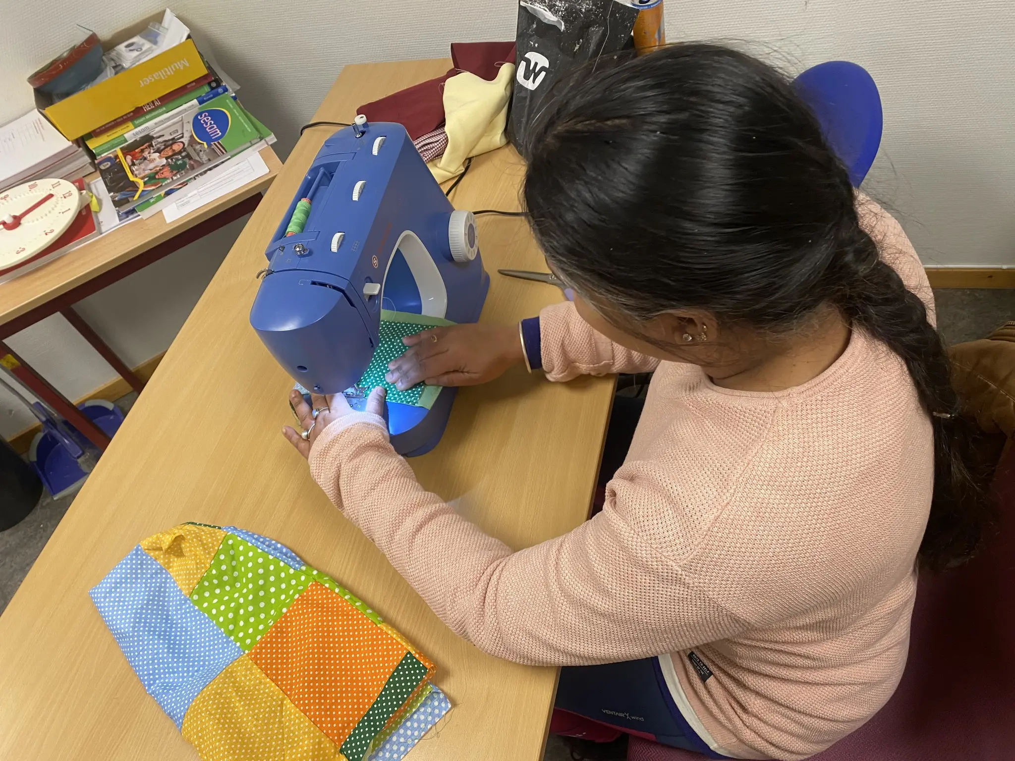 bilde av ei dame som fikser klærne sine på symaskin