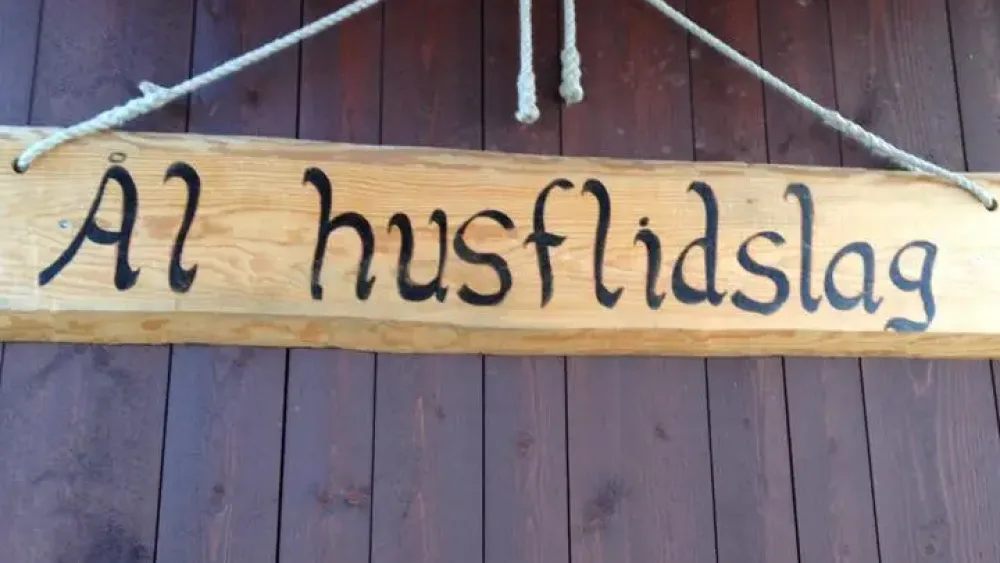 Bilde av et skilt i tre hvor det står Ål husflidslag